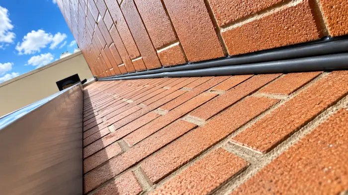 Expansion joint waterproofing installation on a high school addition